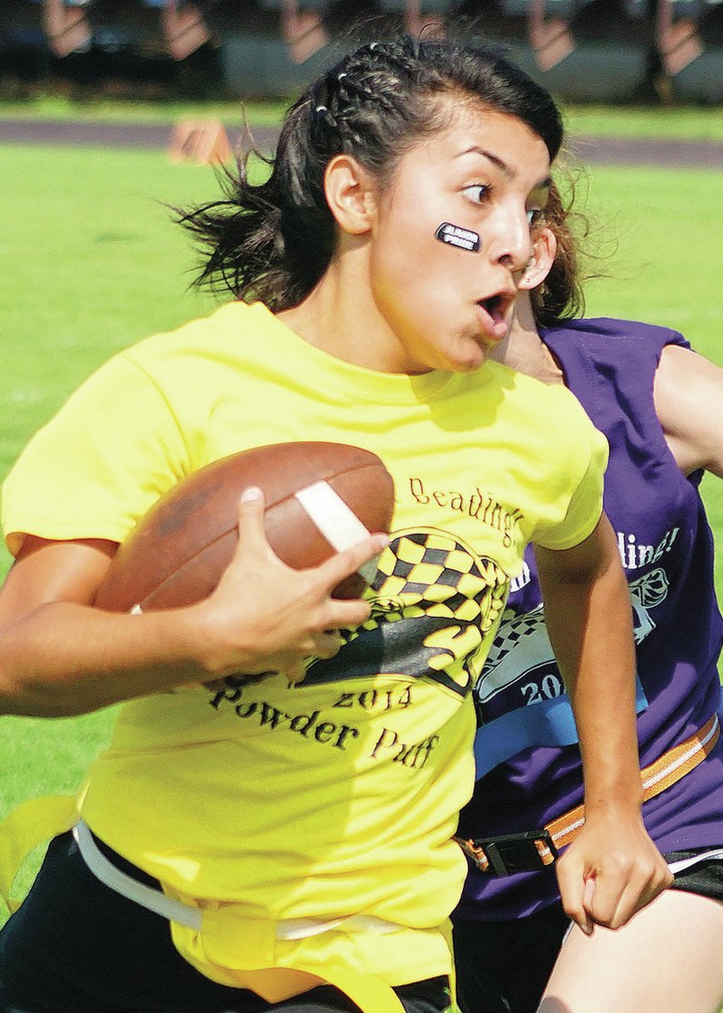Amanda Brenes attempts to escape a senior defender as she carries the ball for the junior class during powder-puff play Sept. 17 in Pioneer Stadium at Gentry High School.