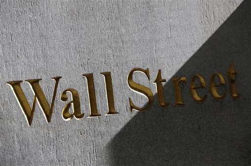 This March 4, 2013 file photo shows a sign for Wall Street on the side of building near the New York Stock Exchange, in New York. U.S. stocks are opening lower Tuesday, Sept. 23, 2014, following disappointing economic news and U.S.-led airstrikes against Islamic State militants in Syria. 