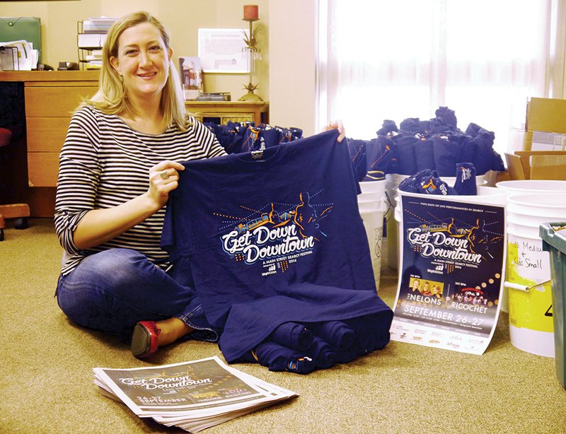 Amy Burton, executive director of the Main Street Searcy nonprofit organization, prepares merchandise to be sold at this year’s Get Down Downtown festival, to be held Sept. 26-27 in Searcy.