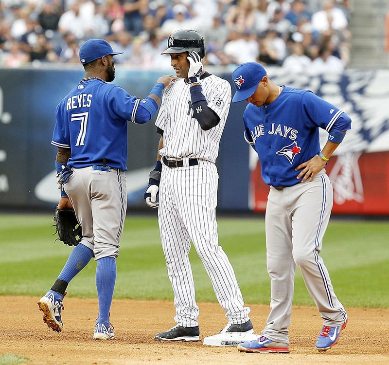 New York Yankees shortstop Derek Jeter (center) talks with Toronto shortstop Jose Reyes (7) during a pitching change in Sunday’s game. Scenes like this have been more common with Jeter winding down his career this season.