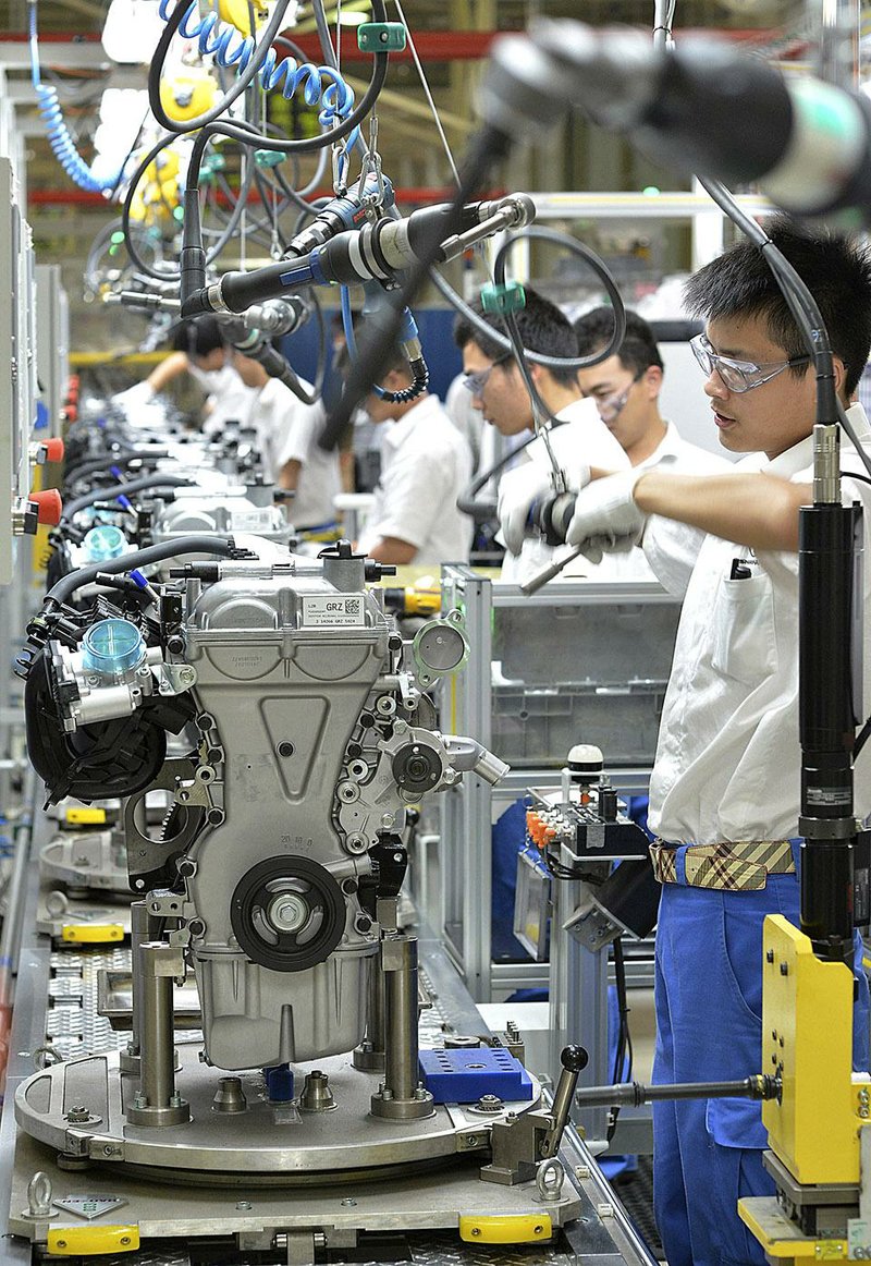 Workers assemble engines on a production line at the General Motors engine plant in Wuhan, China on Tuesday. GM auto sales in China should exceed last year’s 3.1 million vehicles, a company offi cial said Wednesday.