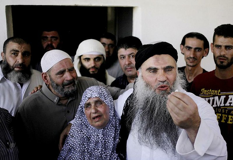 Al-Qaida-linked preacher Abu Qatada celebrates his release from prison Wednesday with his mother Aisha beside him at his parents’ home in Amman, Jordan.