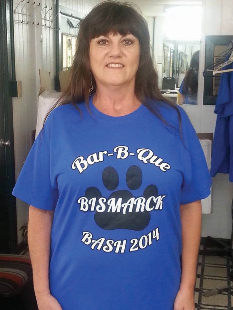 Submitted photo FUNDRAISER: Lavonda Leonard, president of the Bismarck Business Association, shows the 2014 Bismarck Bar-B-Que Bash T-shirt that will be sold this weekend to help support the organization's scholarship fund.
