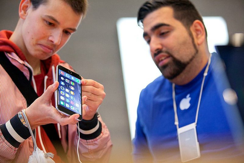 Bloomberg Photo Service 'Best of the Week': A customer, left, holds a iPhone 6 Plus during the sales launch of the latest Apple Inc. iPhone 6 and iPhone 6 Plus smartphones at the Apple store in Berlin, Germany, on Friday, Sept. 19, 2014. The devices generate more than half of Apple's annual $171 billion in revenue and precede a swath of other products, including new iPads and Apple Watch. Photographer: Krisztian Bocsi/Bloomberg
