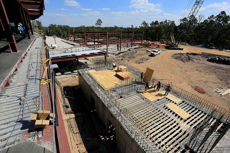 Arkansas Democrat-Gazette/RICK MCFARLAND --09/25/14--  Construction continues on the new $90 million CARTI building in Little Rock Thursday. It is currently the largest project under construction in Little Rock. Workers lay decking on the building (right), with 8 feet thick walls, that will house the linear acceleration vault used for radiation treatments. 
