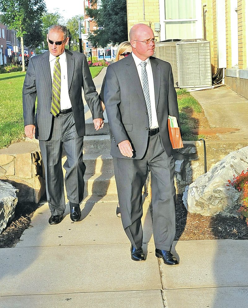 STAFF PHOTO FLIP PUTTHOFF Barry Gebhart, left, and his attorney, Drew Miller, right, arrive Thursday at the Benton County Courthouse in Bentonville.