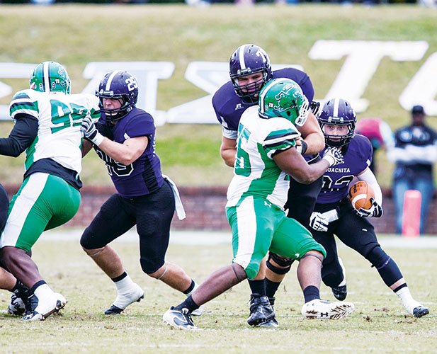 Spencer Knight, No. 25 in purple, blocks for a teammate while the Ouachita Baptist Tigers work on offense in a game against the University of Arkansas at Monticello Boll Weevils. Knight rarely carries the ball from his fullback position, but he has carried his good will into the Arkadelphia community and beyond, even donating bone marrow to someone he does not know — a 3-year-old Canadian boy.