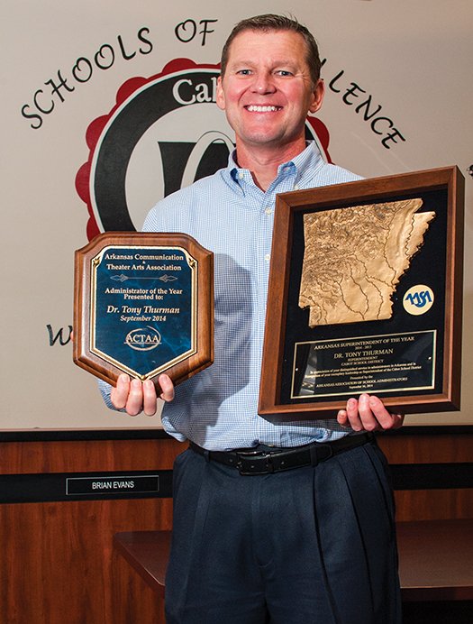 Tony Thurman, superintendent of the Cabot School District, holds two awards he received recently: Administrator of the Year, left, and Superintendent of the Year, right.