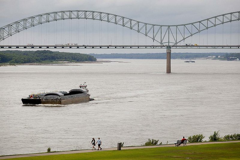 A barge moves along the Mississippi River toward the Hernando de Soto bridge in Memphis in August. The U.S. economy has rebounded from a dismal first quarter with a second quarter in which consumer spending increased.