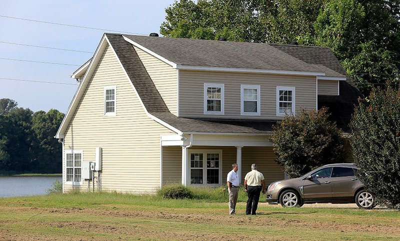 Arkansas Democrat-Gazette/RICK MCFARLAND --09/26/14--   Pulaski County Sheriff's detectives talk outside a vacant house in Scott Friday morning following the disappearence of Beverly Cartrer, 49, who was reported missing Thursday evening after she failed to return from showing a house for sale at 14202 Old River Rd. Her car was still parked there (right).