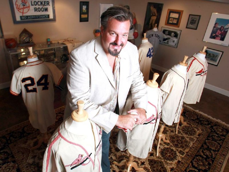 Photo archive owner John Rogers poses with his collection of baseball jerseys at his his home in North Little Rock in 2011.