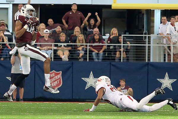 Texas A&M receiver Edward Pope scores on an 86-yard touchdown pass as Arkansas cornerback Jared Collins watches Saturday, Sept. 27, 2014 at AT&T Stadium in Arlington, Texas. 