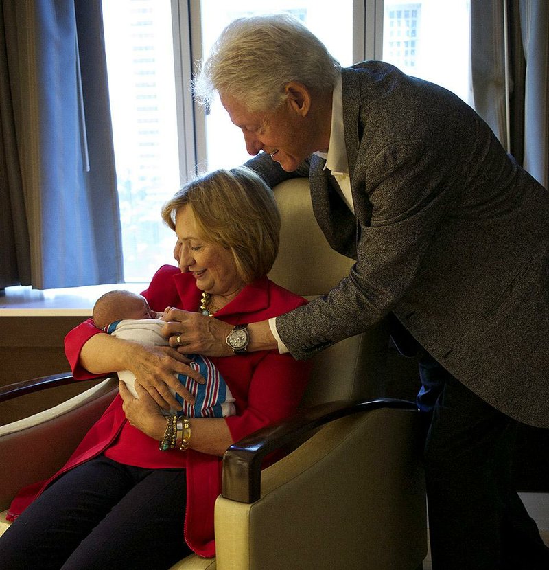 Bill and Hillary Clinton coo over their new granddaughter, Charlotte Clinton Mezvinsky, on Saturday in New York.