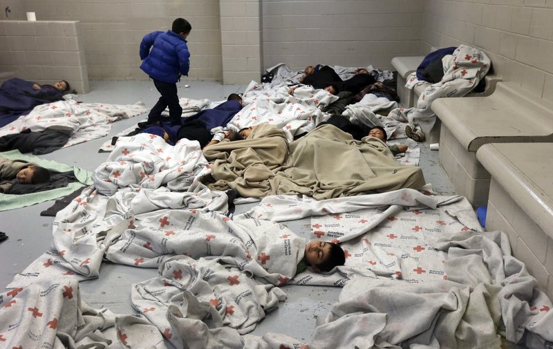 In this June 18, 2014, file photo, detainees sleep in a holding cell at a U.S. Customs and Border Protection processing facility in Brownsville,Texas. More than half of the nearly 60,000 Central America children who have arrived on the U.S.-Mexico border in the past year still don't have lawyers to represent them in immigration court and many of those who do have volunteer attorneys scrambling to brush up on immigration law. Advocates are holding training sessions to help private sector attorneys learn how to work with traumatized, Spanish-speaking children, many of whom have come fleeing violence.
