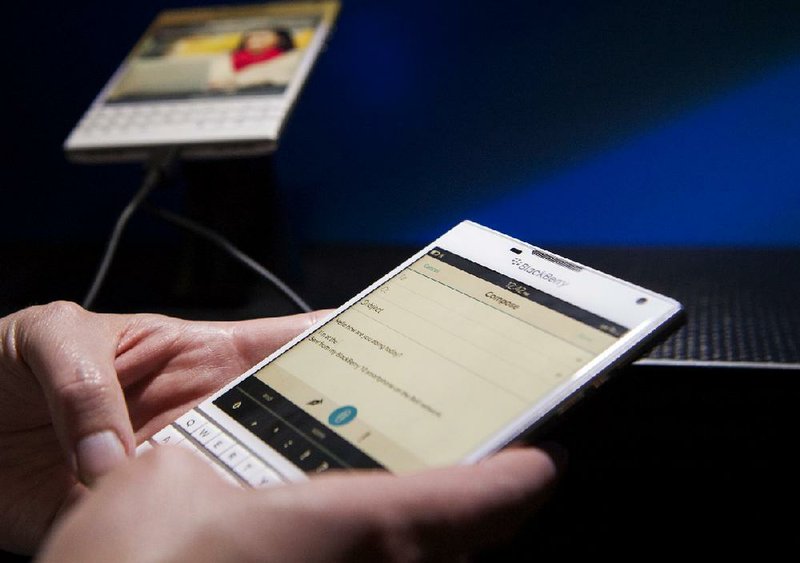 An attendee demonstrates a BlackBerry Ltd. Passport smartphone during a product announcement in Toronto, Ontario, Canada, on Wednesday, Sept. 24, 2014. The square-screened Passport is BlackBerry's first major new device slated for a global introduction since Chief Executive Officer John Chen set out in November to turn around the company by shifting away from the consumer market toward business and professional users. Photographer: Hannah Yoon/Bloomberg
