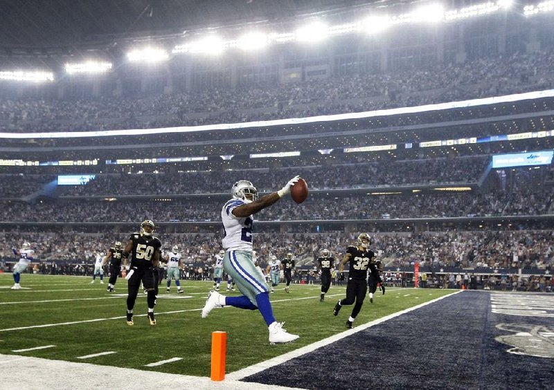 Dallas Cowboys' DeMarco Murray (29) scores on a running play in front of New Orleans Saints' Curtis Lofton (50) and Kenny Vaccaro (32) during the first half of an NFL football game Sunday, Sept. 28,2014, in Arlington, Texas. (AP Photo/Brandon Wade)