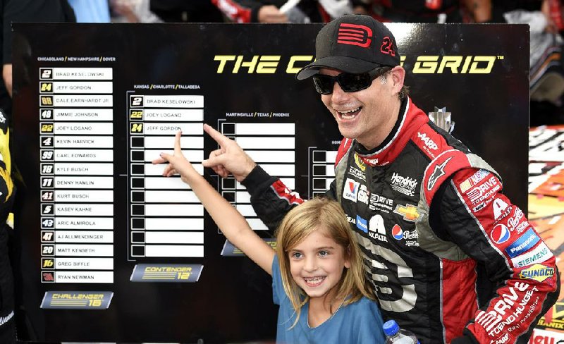 Jeff Gordon, right, and his daughter Ella Sofia, left, point to his name on the Chase Grid in Victory Lane after he won the NASCAR Sprint Cup series auto race, Sunday, Sept. 28, 2014, at Dover International Speedway in Dover, Del. (AP Photo/Nick Wass)