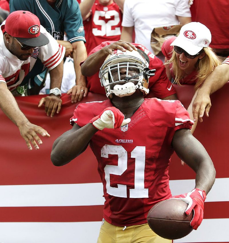 San Francisco 49ers running back Frank Gore (21) celebrates with fans after scoring on a 55-yard touchdown reception against the Philadelphia Eagles during the second quarter of an NFL football game in Santa Clara, Calif., Sunday, Sept. 28, 2014. (AP Photo/Marcio Jose Sanchez)