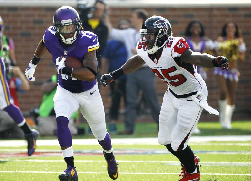 Minnesota Vikings wide receiver Jarius Wright, left, runs from Atlanta Falcons strong safety William Moore, right, after making a reception during the first half of an NFL football game, Sunday, Sept. 28, 2014, in Minneapolis. (AP Photo/Ann Heisenfelt)