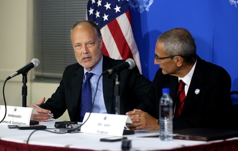 U.S. ambassador to Afghanistan James Cunnigham, left, speaks as Counselor to U.S. president John D. Podesta, right, listens during a news conference at the U.S. embassy in Kabul, Afghanistan, Monday, Sept. 29, 2014. A senior adviser to U.S. President Barack Obama said Monday that Afghanistan will sign a deal Tuesday to allow American soldiers to remain in the country past the end of the year. 