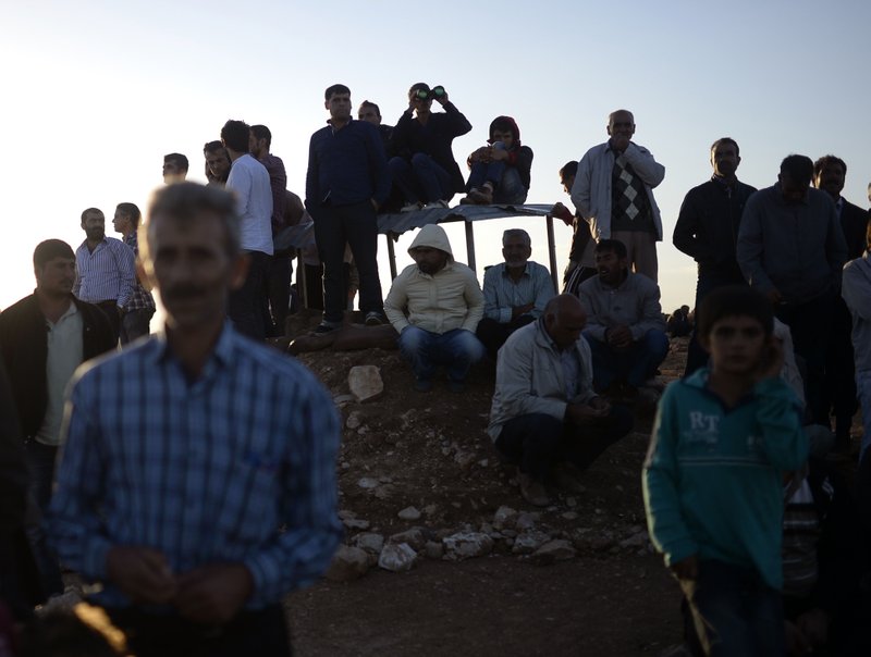 Turkish Kurds watch clashes between Syrian Kurdish fi ghters and militants of the Islamic State near
Suruc, Turkey, on Sunday.