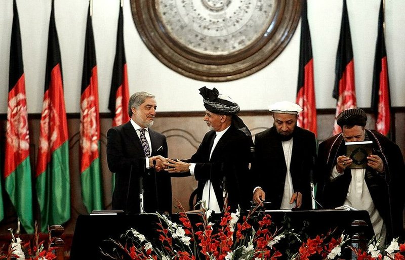 Afghan President Ashraf Ghani Ahmadzai, second left, shakes hands with chief executive Abdullah Abdullah, left, during his inauguration ceremony at the presidential palace in Kabul, Afghanistan, Monday, Sept. 29, 2014. Ghani Ahmadzai replaces Hamid Karzai in the country's first democratic transfer of power since the 2001 U.S.-led invasion toppled the Taliban. (AP Photo/Rahmat Gul)