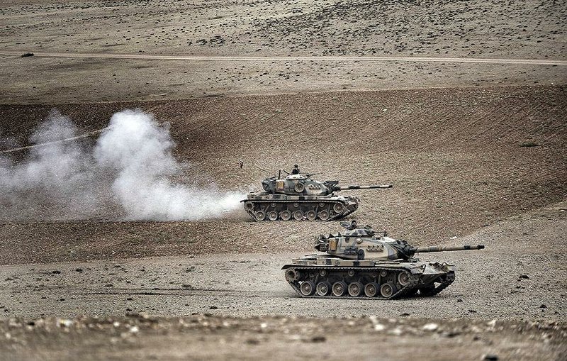 Turkish tanks roll to take positions along the Turkey-Syria border near Suruc, Turkey, Monday, Sept. 29, 2014. U.S.-led coalition air raids targeted towns and villages in northern and eastern Syria controlled by the Islamic State group, including one strike that hit a grain silo and reportedly killed civilians, activists said Monday.(AP Photo/Burhan Ozbilici)