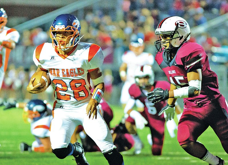 Special to NWA Media David J. Beach Joey Saucier of Rogers Heritage dodges Kender Bolkeim of Springdale High on Friday at Jarrell Williams Bulldog Stadium in Springdale.