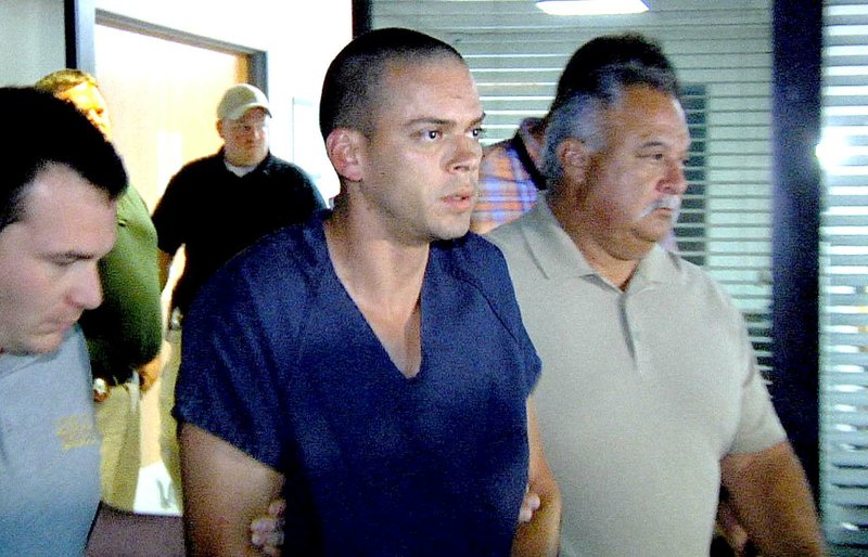 FILE — Arron Lewis is escorted by authorities at the Pulaski County sheriff's office in this September 2014 file photo.