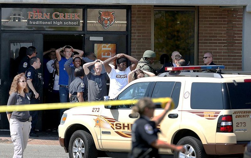 Students put their hands on their heads as they are led out of Fern Creek Traditional High School in Louisville, Ky., on Tuesday after a student was shot.