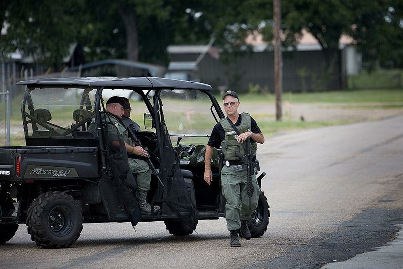 Miller County Sheriffs Deputies aid in the search for escaped inmate Jeremy Shane Pifer, Tuesday, Sept. 30, 2014, in Fouke, Ark.  Officials says the 36-year-old Pifer ran away, Thursday, Sept. 25, 2014, from a work crew that was picking up trash along U.S. 71 in Fouke, and disappeared into a wooded area.  (AP Photo/The Texarkana Gazette, Evan Lewis)