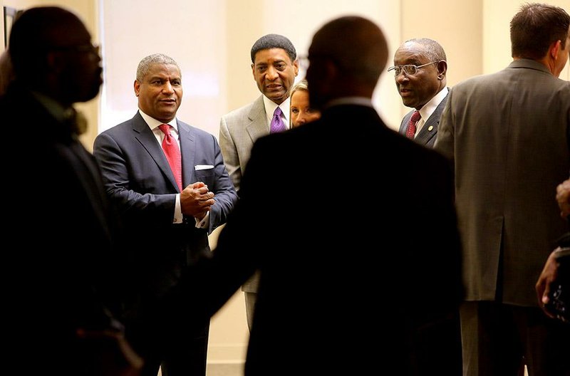 Former U.S. Transportation Secretary Rodney Slater (left, facing camera) chats with Charles Stewart (center), Sherman Tate (right), and others prior to a transportation panel discussion Tuesday at Philander Smith College in Little Rock.