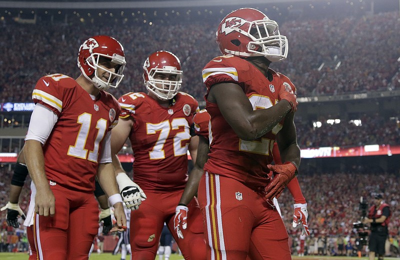 The Associated Press KC'S TOP 40, PLUS ONE: Jamaal Charles, right, scores a third-quarter touchdown as teammates Alex Smith, left, and Eric Fisher look on as the Kansas City Chiefs pound the visiting New England Patriots 41-14 Monday night. Charles returned from an ankle injury to score three touchdowns, and ex-Arkansas Razorback Knile Davis ran for 107 yards.