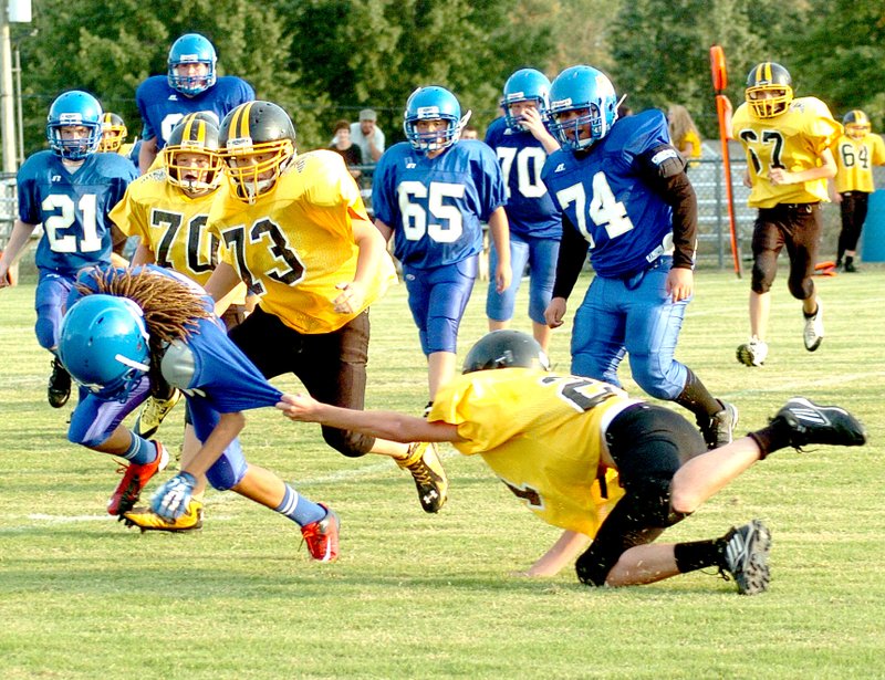 Photo by Mike Eckels A Hackett player grabs the sleeve of Decatur&#8217;s Tafari James (#15) for a tackle as James was attempting to find a hole during the Sept. 25 seventh-grade game with the Hornets at Bulldog Stadium. Decatur was defeated by Hackett, 19 to 6.