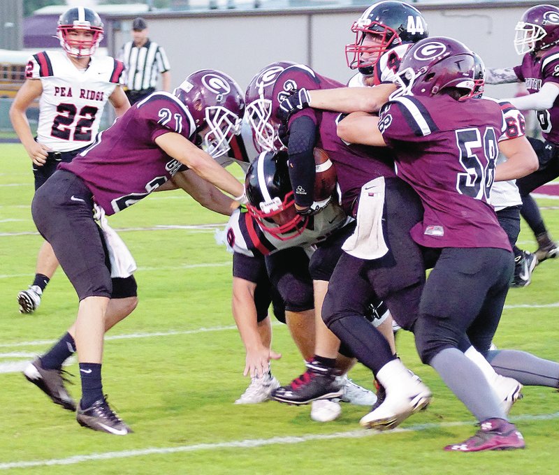 Photo by Randy Moll Gentry running back Jon Brown is tackled by Dakota Canaday and Seth Brumley of Pea Ridge while Kaven Flesner and Bryan Harris of Gentry attempt to block during play between the two rival teams in Gentry on Friday.