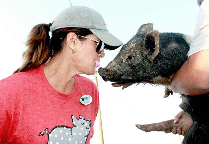 Cammi Hevener used fake lips to kiss a pig during the Cowboy Olympics. The event is used to raise money for Project Graduation, which provides an alternative event after graduation for seniors.