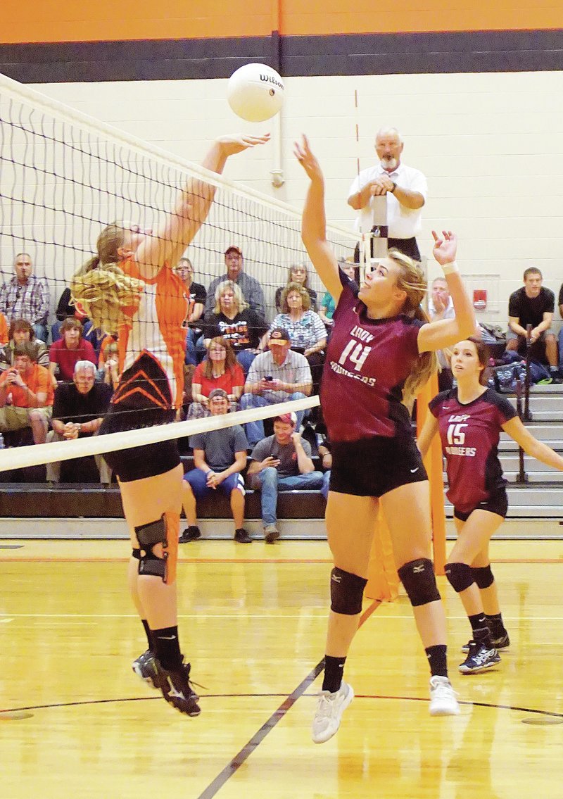 Photo by Randy Moll Gravette junior Amanda Pinter faces off at the net with Gentry junior Haley Borgeteien-James on Sept. 23 in play between the two teams at Gentry. Gentry&#8217;s Brandy Murphy is in the background. Gravette defeated Gentry, 3-1: 25-21, 26-28, 25-21 and 25-9. Shannon McKnight led Gravette with 6 kills, 1 block and 11 digs. DaMayla Cowan added 5 kills and 2 blocks. Amanda Pinter led the team in serving with 16 points. She also had 5 kills and 2 blocks. Gravette coach, Robin Cannon, said: &#8220;The game experience that we have gotten the last three weeks is starting to show. We began the year with talent, but lack of experience. The girls are becoming more comfortable with their roles on the court and, more importantly, more comfortable with each other. I think if we continue to improve each match, we will be able to compete with anyone in our conference. We still have areas that we need to improve, but I see the progress and I know the talent is there. We have a tough stretch coming up. We travel to Prairie Grove and Pea Ridge. Both are very good teams, but I feel like if we go out and compete like we are capable they are very winnable matches for us.&#8221;