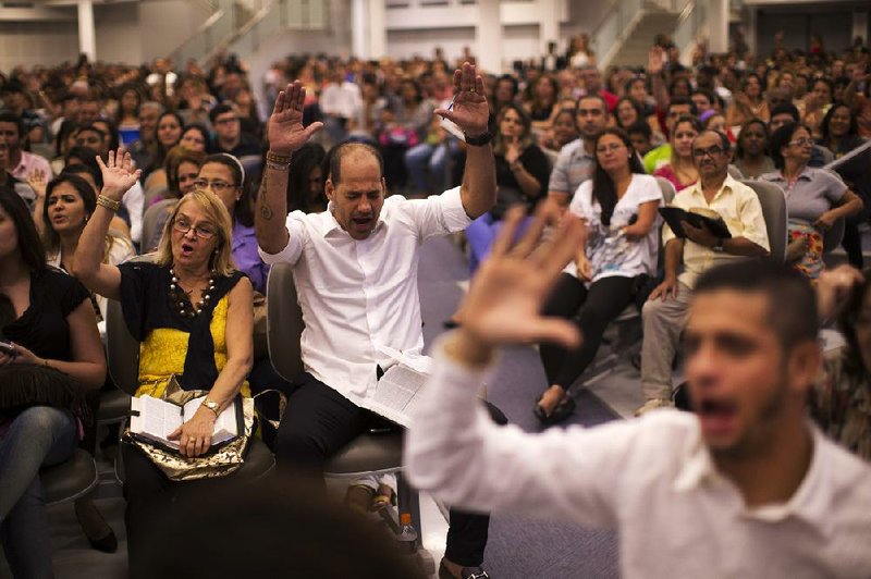 Worshippers raise their hands in prayer as they listen to Pastor Silas Malafaia in Rio de Janeiro. Pentecostals are a growing influence in the traditionally Catholic country of Brazil.