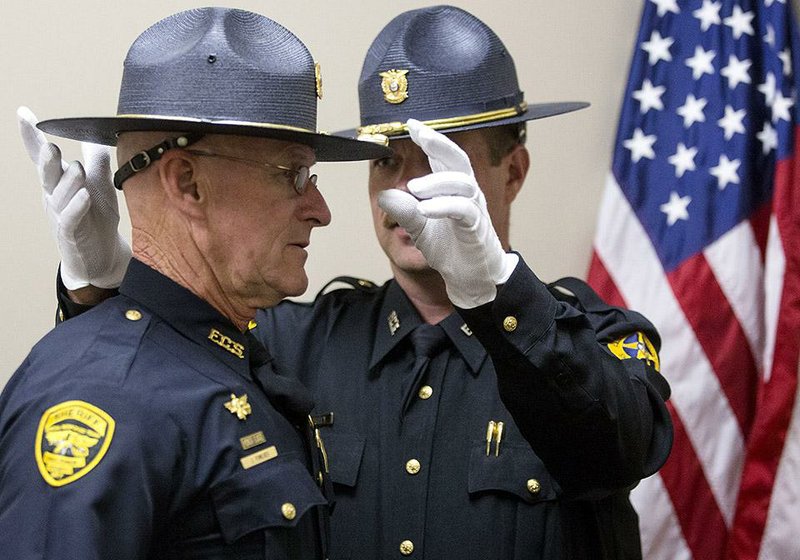 Faulkner County sheriff’s Deputy Nathan Kelley adjusts fellow Deputy John Fowlkes’ hat before a ceremony at the new county courthouse in Conway on Thursday.