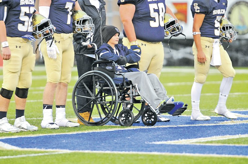 STAFF PHOTO J.T. WAMPLER Gunnison Riggins appeared as a honorary captain when Shiloh Christian took the field against First Baptist of Naples, Fla., on Sept. 12. Riggins was in a wheelchair after suffering a broken leg.