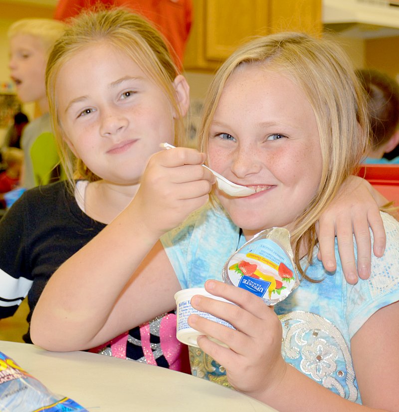 Janelle Jessen Lee Ann Groover and Lilly Higgs had yogurt cups during snack time on Friday at the Boys &amp; Girls Club in Siloam Springs.