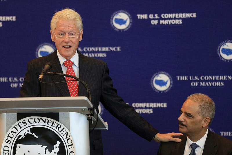 Former President Bill Clinton acknowledges U.S. Attorney General Eric Holder during a meeting of the U.S. Conference of Mayors at the Clinton Presidential Center in Little Rock on Wednesday.
