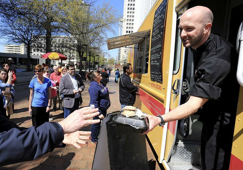 Justin Patterson serves a customer from his Southern Gourmasian food truck.