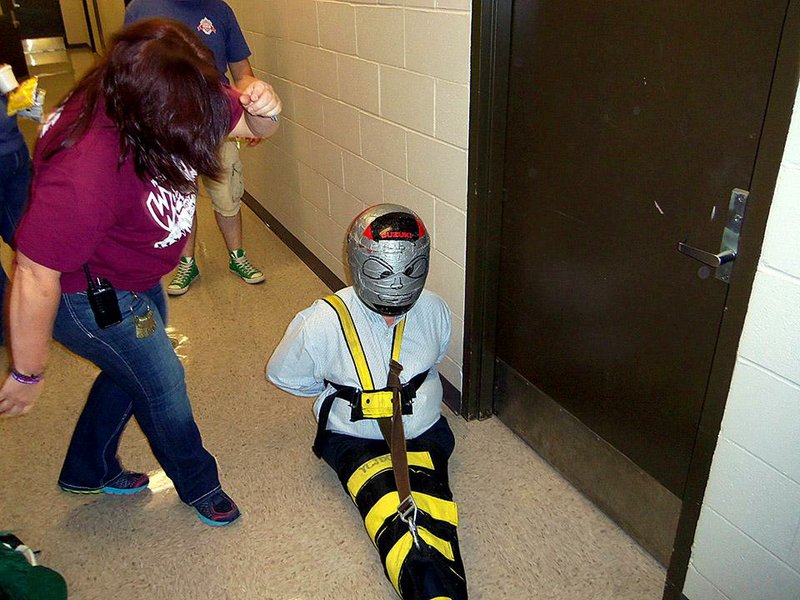 Yell County Juvenile Detention Center staff members demonstrate The Wrap restraint system on Scott Tanner, the state’s juvenile-justice ombudsman, in this undated photo. The center used the device and a duct tape-covered motorcycle helmet to restrain disruptive youths until the Youth Services Division learned of it and demanded an end to the practice. Photo obtained through the Arkansas Freedom of Information Act.