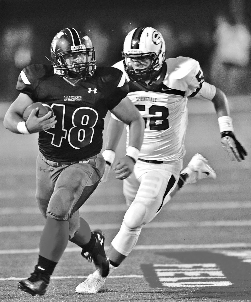 STAFF PHOTO ANDY SHUPE Jonathan Wilits of Fayetteville carries the ball after making a catch as Jaime Argueta of Springdale High pursues during the first half at Harmon Stadium in Fayetteville.