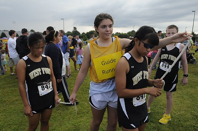 Rosanna Scott, from left, guide runner Sidney Brock and Jenna Scott go to the starting area for their first cross country race on Saturday Aug. 30 2014 during a meet at Shiloh Christian school.