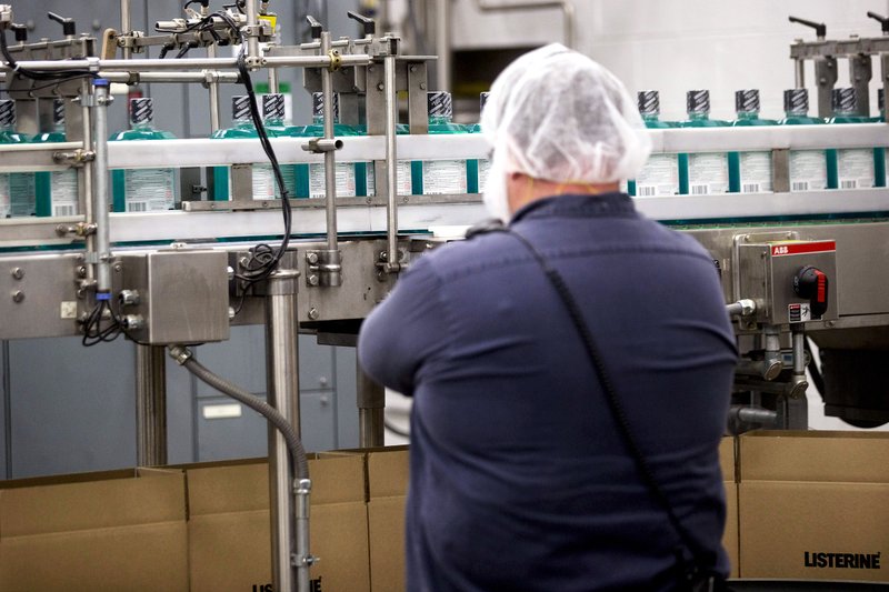An employee monitors Johnson & Johnson Listerine mouthwash bottles as they move through the production line on a conveyor in Lititz, Pa., earlier this year.