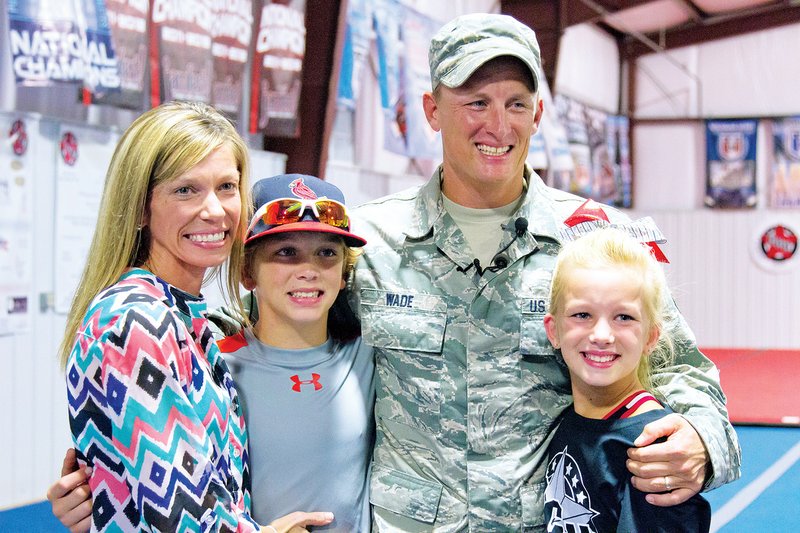 From left, Stephanie, Masen, Jeff and Abigail Wade smile for a family photo after Jeff, a master sergeant in the U.S. Air Force, surprised Abigail at cheer practice. He had been deployed for six months.
