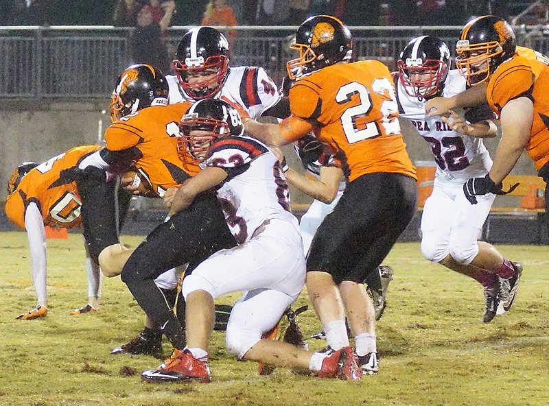 Photograph by Randy Moll Pea Ridge senior Jonathon Small tackles Gravette junior Bryce Moorman during a rainy night of play in Gravette on Friday.