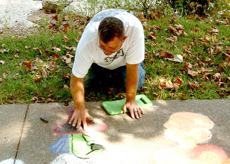 Photo by Mike Eckels Mike Kelly from Gravette works on his latest sidewalk creation at Crystal Lake Oct. 8. Kelly recreated a scene from the Charles Schultz Peanuts classic &#8220;It&#8217;s the Great Pumpkin, Charlie Brown.&#8221;